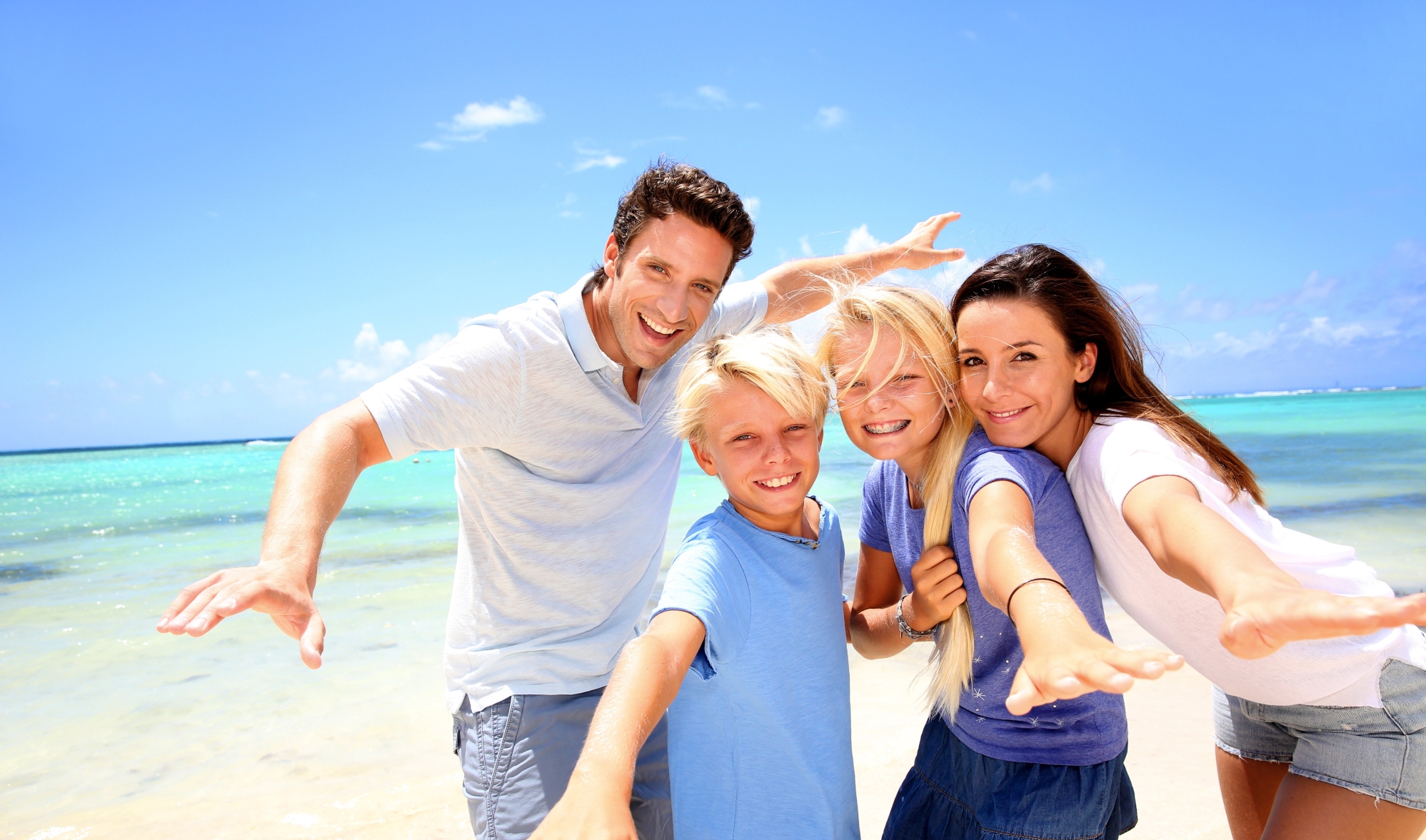 Familie met kinderen op het strand